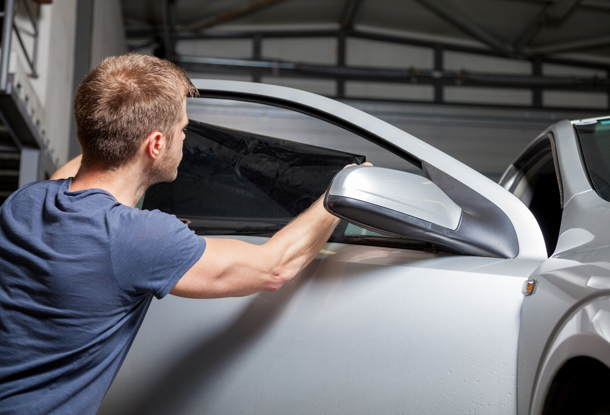 man applying window tinting